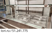 Empty stainless steel food serving trays in cafeteria with glass partition. Стоковое фото, фотограф Zakharova Natasha / Фотобанк Лори