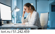 Business stress concept showing tired woman with headache working late at night, frustrated female manager feeling burnout from computer work in dark office. Стоковое AI-изображение, AI-художник Павел Муравьев / Фотобанк Лори