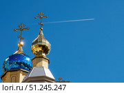 Купола Церкви Пантелеимона Целителя в ессентуках. Domes of the temple with crosses against blue sky and flying plane with white trace. Orthodox church and flying airplane (2019 год). Редакционное фото, фотограф Зарифа Арсланова / Фотобанк Лори