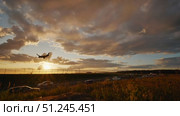 Passenger airplane landing at sunset over highway traffic. Стоковое видео, видеограф Mikhail Davidovich / Фотобанк Лори