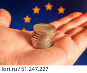 Euro Coins in Hand with European Flag Background. Стоковое фото, фотограф Sergakoff / Фотобанк Лори