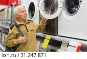 elderly man choosing washing machine in showroom of electrical appliance store. Стоковое фото, фотограф Татьяна Яцевич / Фотобанк Лори