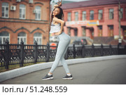 portrait of a girl in jeans and a t-shirt on the background of the building in the evening on a summer day. street dancing in the city. Стоковое фото, фотограф Арзюков Вадим Николаевич / Фотобанк Лори