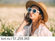 Daisy Field Hat: Woman relaxes in a sunny chamomile field, enjoying springtime. Стоковое фото, фотограф svetograph / Фотобанк Лори