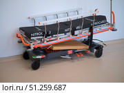 Modern emergency stretcher or patient transport gurney with black mattress Nitrocare and orange accents. Medical equipment for hospital or ambulance - Moscow, Russia, September 06, 2025. Редакционное фото, фотограф Андрей Журавлев / Фотобанк Лори