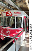 Istanbul red retro tram isolated on white background. Travels between Taksim and Tunnel. Translation: Tunnel Winter and Red Tram in Istiklal Street, Beyoglu, Istanbul. The second underground metro in the world, Istanbul Taksim Tunnel. Turkey Istiklal Avenue, Tunel, Beyoglu, Istanbul. Редакционное фото, фотограф Zita Khasanova / Фотобанк Лори