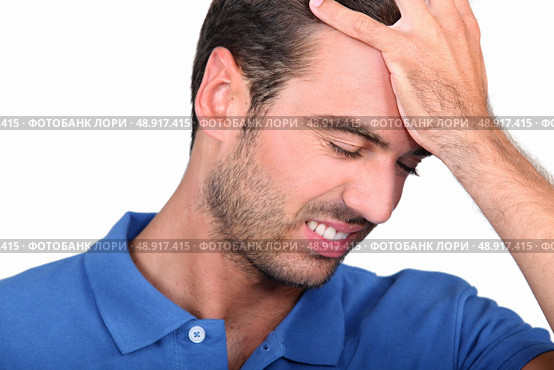 a 35 years old man taking his head with his hand, his face expresses failure. Стоковое фото, агентство Ingram Publishing / Фотобанк Лори