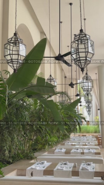 A beautiful and ornate Arabic-style dining room filled with food, an Arabian night if tar, dinner party concept Outdoor dining experience under warm, golden light.  Arabic-style lanterns and string lights illuminate a wooden table laden with various dishes. Стоковое видео, видеограф Zita Khasanova / Фотобанк Лори