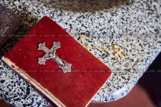 A Bible with a large golden cross on the cover. Next to it is a Christian symbol - a cross. The Baptism of man. Стоковое фото, фотограф Наталия Кирсанова / Фотобанк Лори