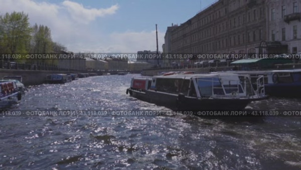 A boat and a tourist boat pass along the Moika River near the intersection with Nevsky Prospekt. Russia. St. Petersburg. 05/08/2024. Редакционное видео, видеограф Ярославский Максим / Фотобанк Лори