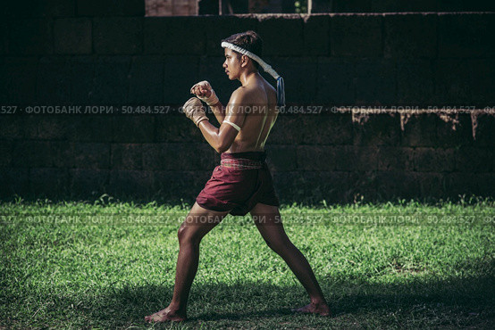 A boxer tied a rope in his hand and performed a fight, The martial arts of Muay Thai. Стоковое фото, агентство Ingram Publishing / Фотобанк Лори