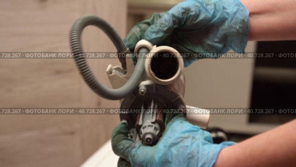 a broken old washing machine water pump in the hands of repairman. Стоковое видео, видеограф Андрей Знаменский / Фотобанк Лори