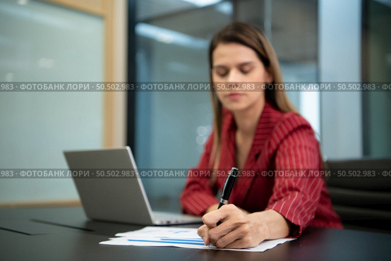 A businesswoman in a crimson gown Prepare to present work and new projects for consideration to the management team. in the huge conference room of the corporation. Стоковое фото, агентство Ingram Publishing / Фотобанк Лори