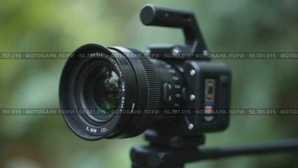 A Camera is Positioned on a Tripod Amidst Greenery, Highlighting Its Lens and Features. Стоковое AI-видео, аниматор Sergey Grishin / Фотобанк Лори