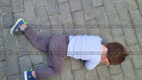 A capricious child lies on the ground in cry refusing to go. Baby aged two years (two-year-old boy) Стоковое видео, видеограф Андрей Журавлев / Фотобанк Лори