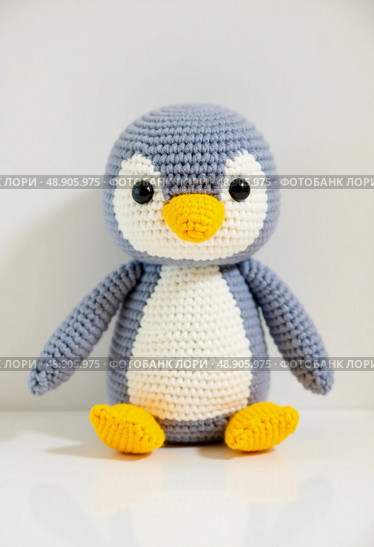 A charming penguin toy made from carefully knitted yarn, featuring soft textures and bright colors that add character and warmth, perfect for imaginative play or display Generative AI. Стоковое AI-изображение, AI-художник Юлия Петровская / Фотобанк Лори