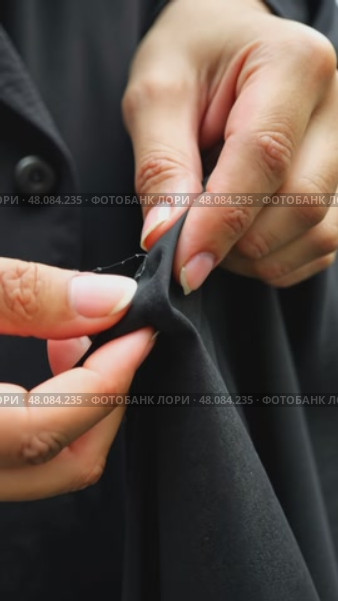 A close-up of a woman's hands sewing a black cloth banner, her fingers trembling slightly as she prepares for the Ashura process. Стоковое AI-видео, аниматор Sergey Grishin / Фотобанк Лори