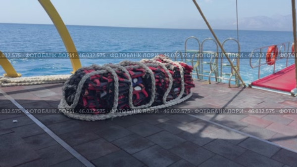 A collection of bright red life jackets is scattered on a wooden deck. Perfect for themes of safety, outdoor activities, and water sports. Стоковое видео, видеограф Ирина Старикова / Фотобанк Лори