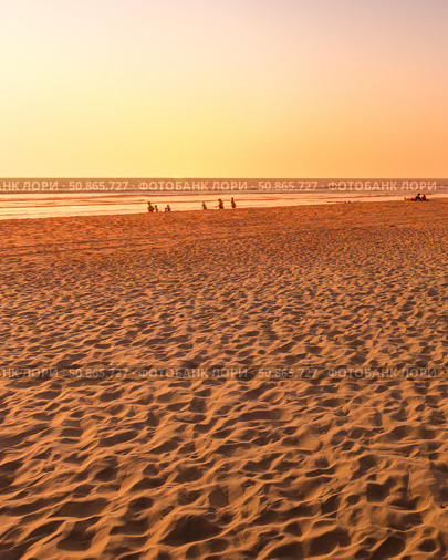 A colorful sunset or sunrise on the seaside with a sandy beach with impurities of volcanic ash. Mandrem, Goa, India. (2018 год). Стоковое фото, фотограф Емельянов Евгений Викторович / Фотобанк Лори