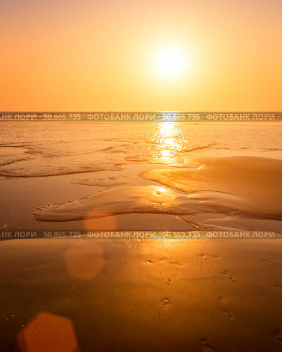 A colorful sunset or sunrise on the seaside with a sandy beach with impurities of volcanic ash. Mandrem, Goa, India. (2018 год). Стоковое фото, фотограф Емельянов Евгений Викторович / Фотобанк Лори