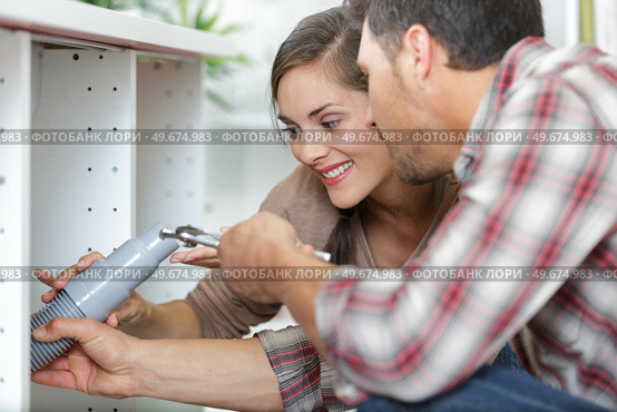 a couple fixing kitchen sink. Стоковое фото, агентство Ingram Publishing / Фотобанк Лори