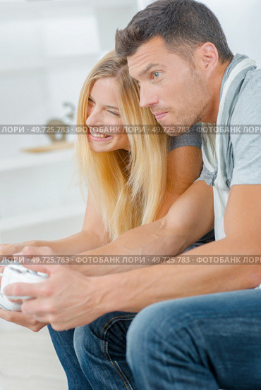 a couple is playing console. Стоковое фото, агентство Ingram Publishing / Фотобанк Лори