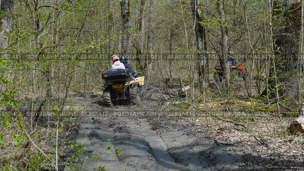 A couple on a yellow ATV riding through mud and puddles in the woods. Back view. Extreme type of outdoor activities. Riding on a quad bike. Стоковое фото, фотограф Воловодов Владимир / Фотобанк Лори