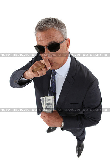 A crook holding stolen money. Стоковое фото, агентство Ingram Publishing / Фотобанк Лори