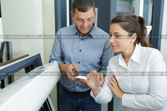 a customer inspecting pvc windows. Стоковое фото, агентство Ingram Publishing / Фотобанк Лори