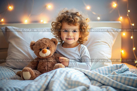 A cute curly-haired girl hugs a teddy bear, sitting in a cozy bed, a small child hugs a toy and gets ready for bed. A healthy night's sleep. Стоковое AI-изображение, AI-художник Photojuli / Фотобанк Лори
