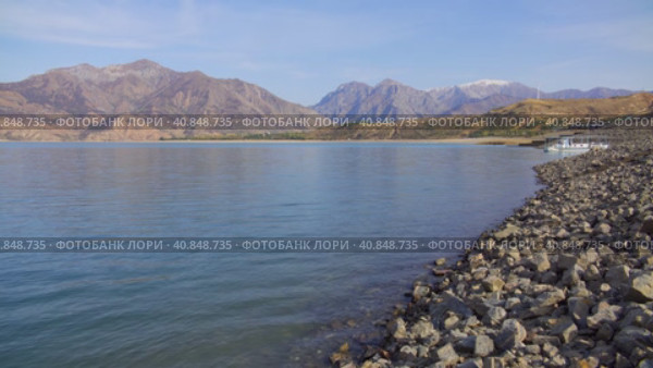 A deep mountain lake surrounded by rocks on a cloudy day. Стоковое видео, видеограф Aleksey Kidisyuk / Фотобанк Лори