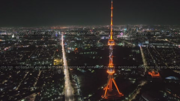 A drone over the city at night flies around a TV tower illuminated by lights. Cloudless Summer Night. Стоковое видео, видеограф Aleksey Kidisyuk / Фотобанк Лори