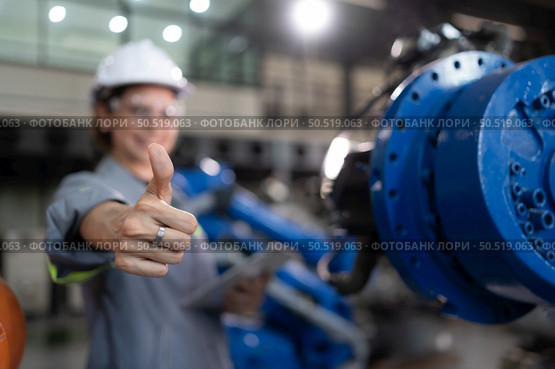 A female engineer completed the updating software and calibrating a robotics arm, Ready to deliver to the next customer. Стоковое фото, агентство Ingram Publishing / Фотобанк Лори