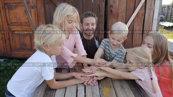 A friendly family joins their hands as a sign of joint success. Стоковое фото, фотограф Mikhail Davidovich / Фотобанк Лори