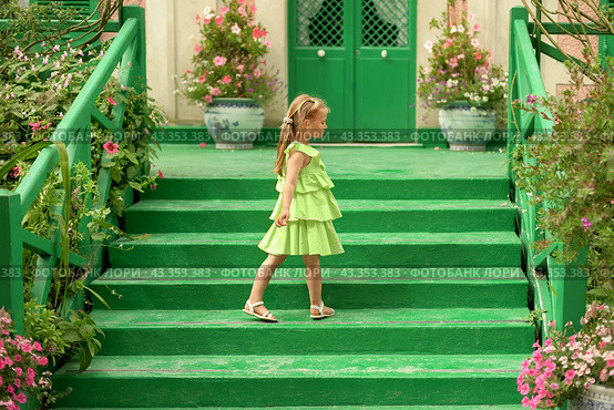 A girl in a green dress in the gardens of Claude Monet in Giverny. Facade of the Monet's house. Стоковое фото, фотограф Irina Kuchugurina/Gaudy / Фотобанк Лори