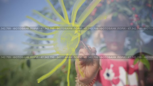 A girl of six years draws the sun on glass. Стоковое видео, видеограф Mikhail Davidovich / Фотобанк Лори