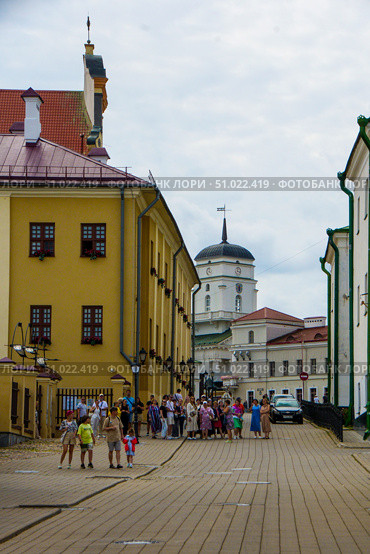 A group of people is walking along the street of an old European city. Belarus. Minsk. 05.08.25. Редакционное фото, фотограф Ярославский Максим / Фотобанк Лори