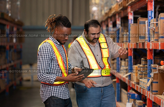 A group of warehouse employees, Inspecting products on warehouse shelves before they are sent to retailer. Стоковое фото, агентство Ingram Publishing / Фотобанк Лори