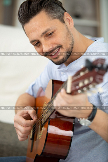 a handsome musician playing guitar. Стоковое фото, агентство Ingram Publishing / Фотобанк Лори