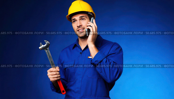 A man in a blue shirt and yellow helmet is talking on a cell phone. Стоковое AI-изображение, AI-художник Ярославский Максим / Фотобанк Лори