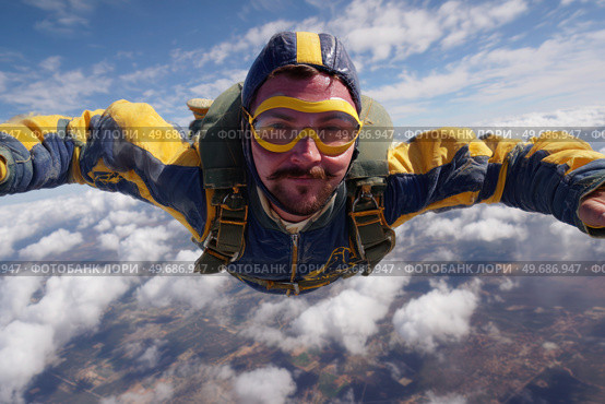A man in a yellow and blue jumpsuit is flying through the air. Стоковое AI-изображение, AI-художник Ярославский Максим / Фотобанк Лори