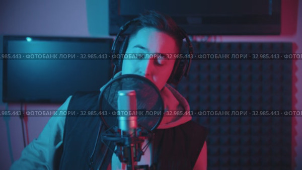A man in hoodie rapping in the sound recording studio. Стоковое видео, видеограф Константин Шишкин / Фотобанк Лори