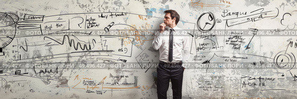 A man is standing against a wall covered in colorful graffiti art, looking contemplative. Стоковое AI-изображение, AI-художник Данила Большаков / Фотобанк Лори