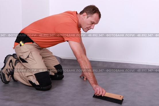 A man laying lino. Стоковое фото, агентство Ingram Publishing / Фотобанк Лори