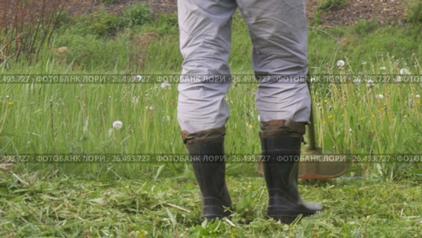 A man mowing the grass in the garden closeup. Стоковое видео, видеограф Игорь Усачев / Фотобанк Лори