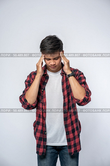 A man who is sick and touches his head with his hand. Стоковое фото, агентство Ingram Publishing / Фотобанк Лори