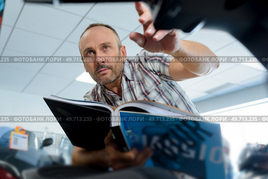 a man with catalogue indoors. Стоковое фото, агентство Ingram Publishing / Фотобанк Лори