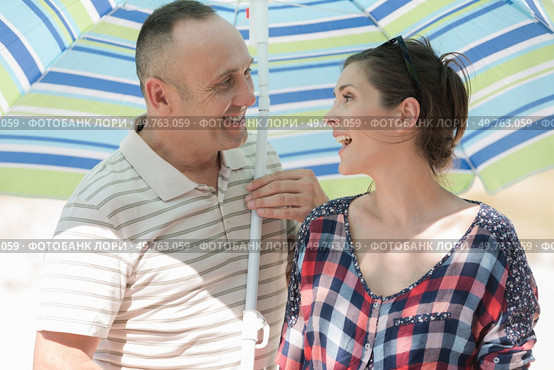 a middle-aged couple under parasol. Стоковое фото, агентство Ingram Publishing / Фотобанк Лори