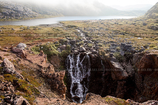 A mountain waterfall in the north of the Kola Peninsula. Waterfall from the Small Battery Lake on the shore of the Barents Sea in Teriberka. (2015 год). Стоковое фото, фотограф Photojuli / Фотобанк Лори