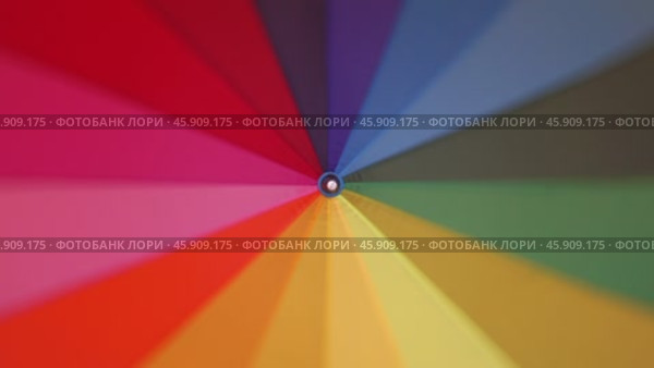 A multi-colored rainbow umbrella rotates. Стоковое видео, видеограф Михаил Коханчиков / Фотобанк Лори
